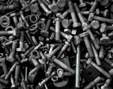 Detailed image of assorted industrial bolts and screws for recycling or mechanics.