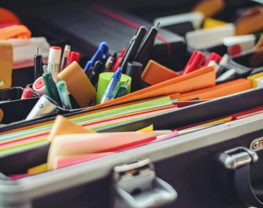 A collection of colorful office supplies neatly arranged in a suitcase, perfect for professionals on the go.